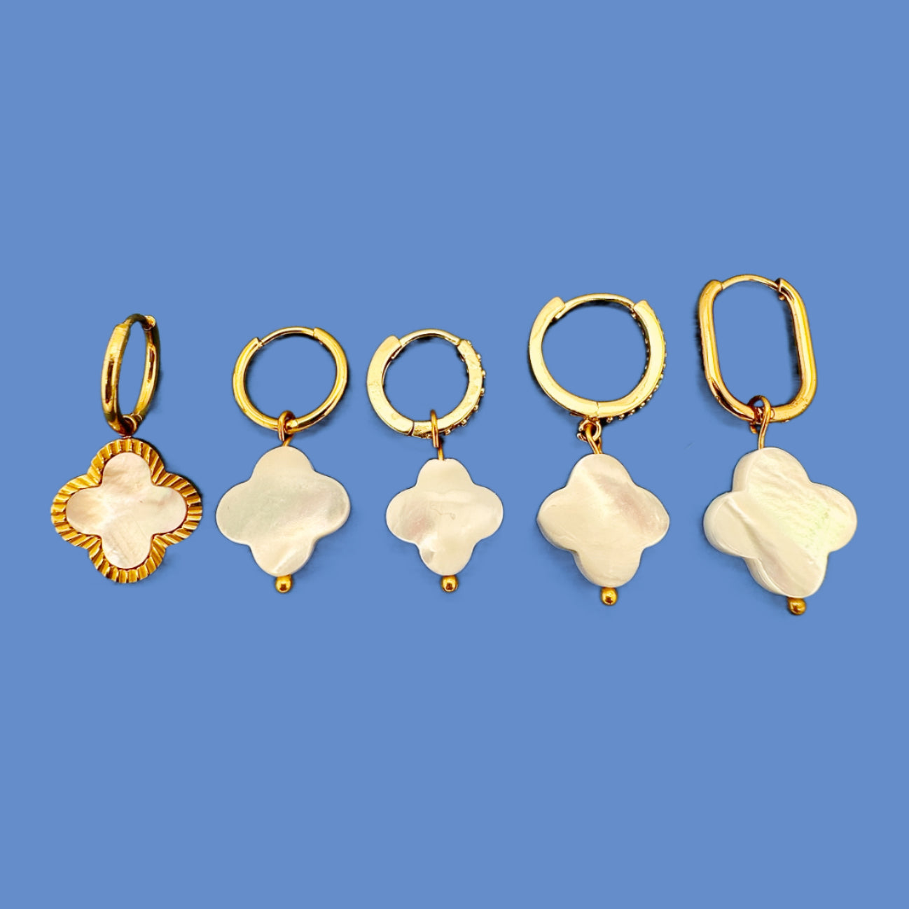 group of gold hoop earrings with clover shaped charms