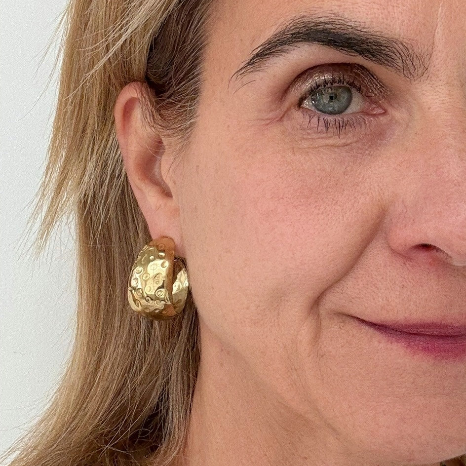 Big rounded gold hoop earrings on model