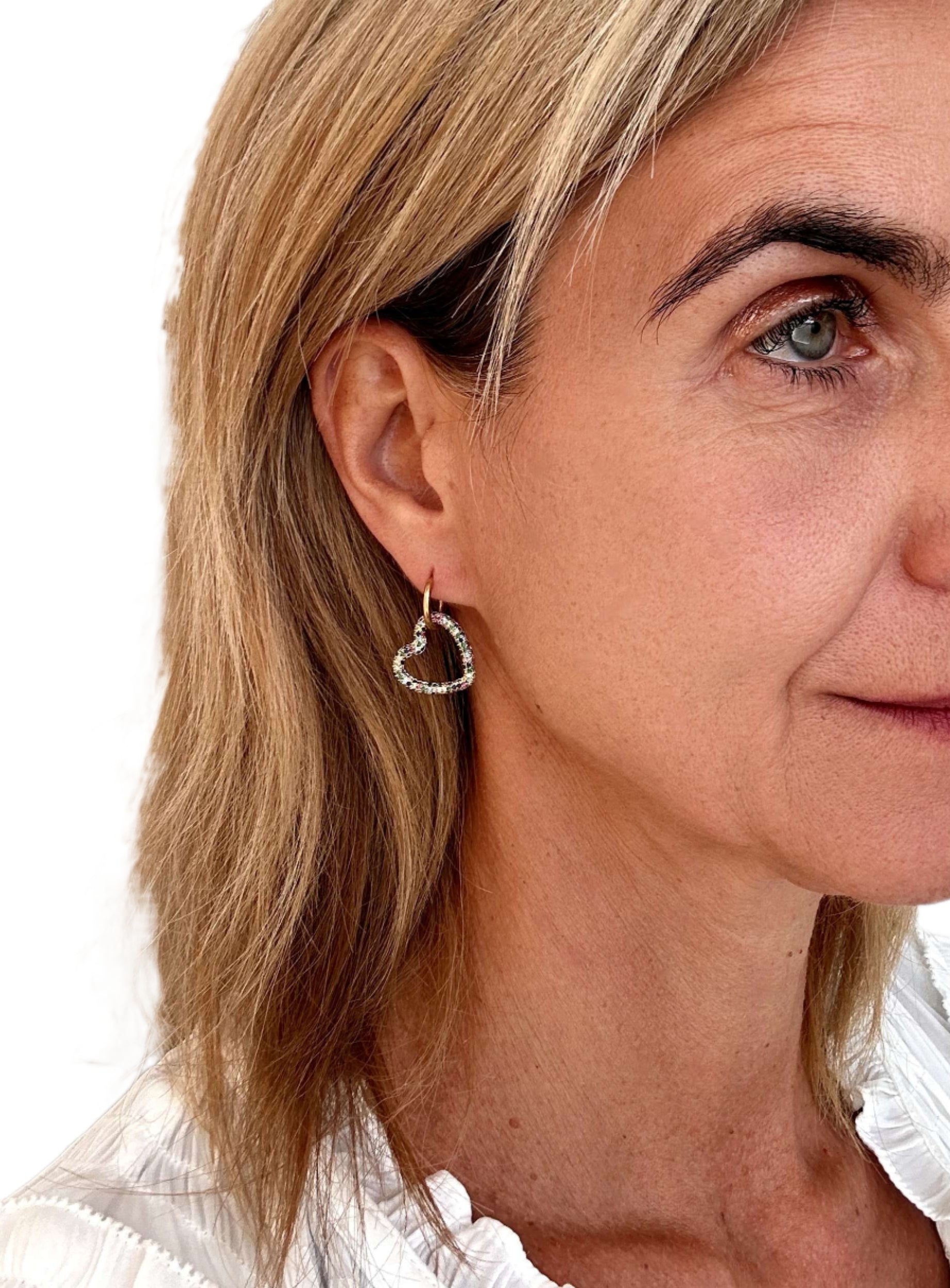 gold hoop earrings with large rainbow heart-shaped charms