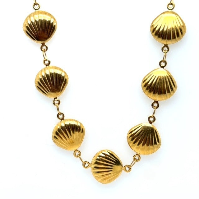 Gold shell-shaped necklace on a white background