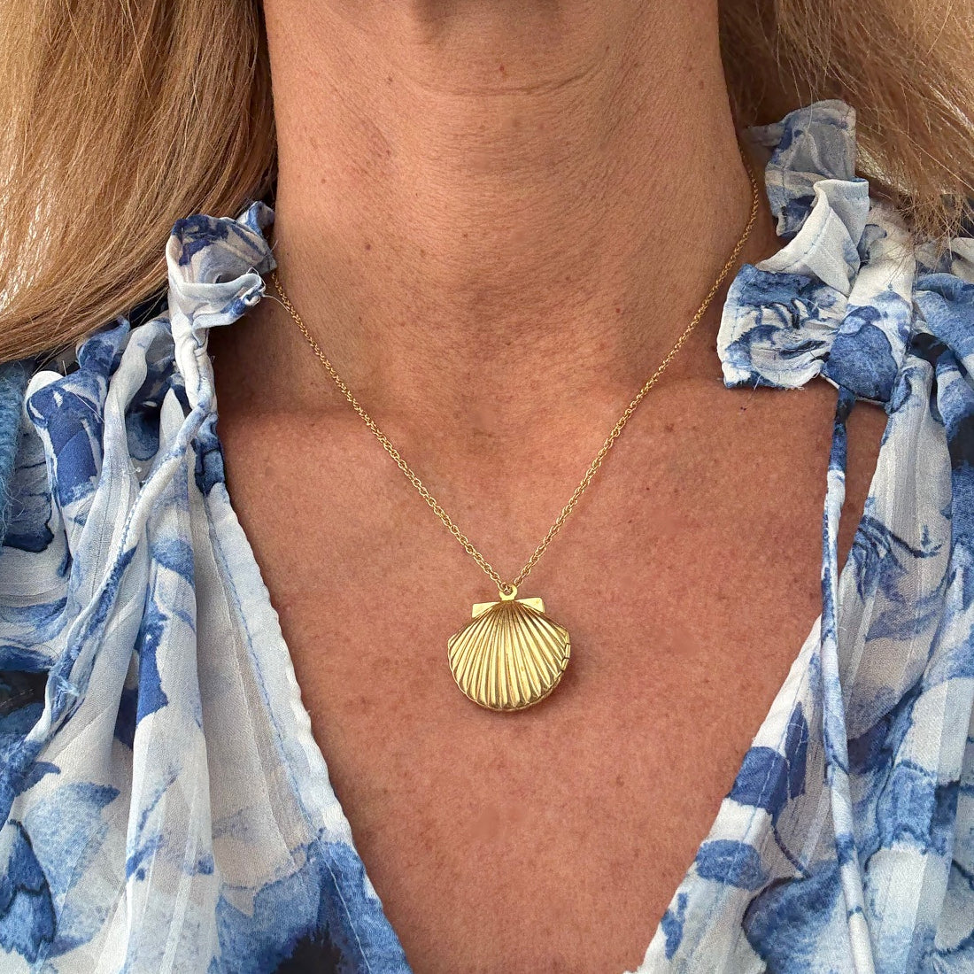 woman wearring shell shaped locket necklace