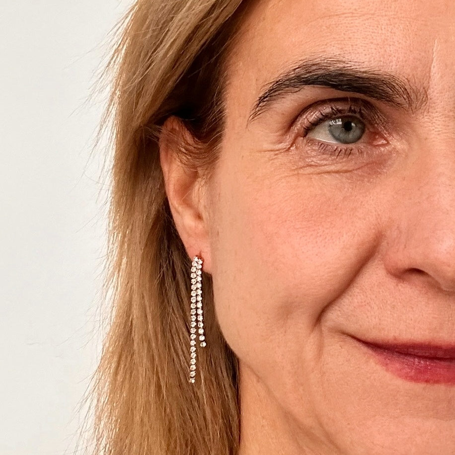 sparkly earrings have two dangling rows of crystals on model