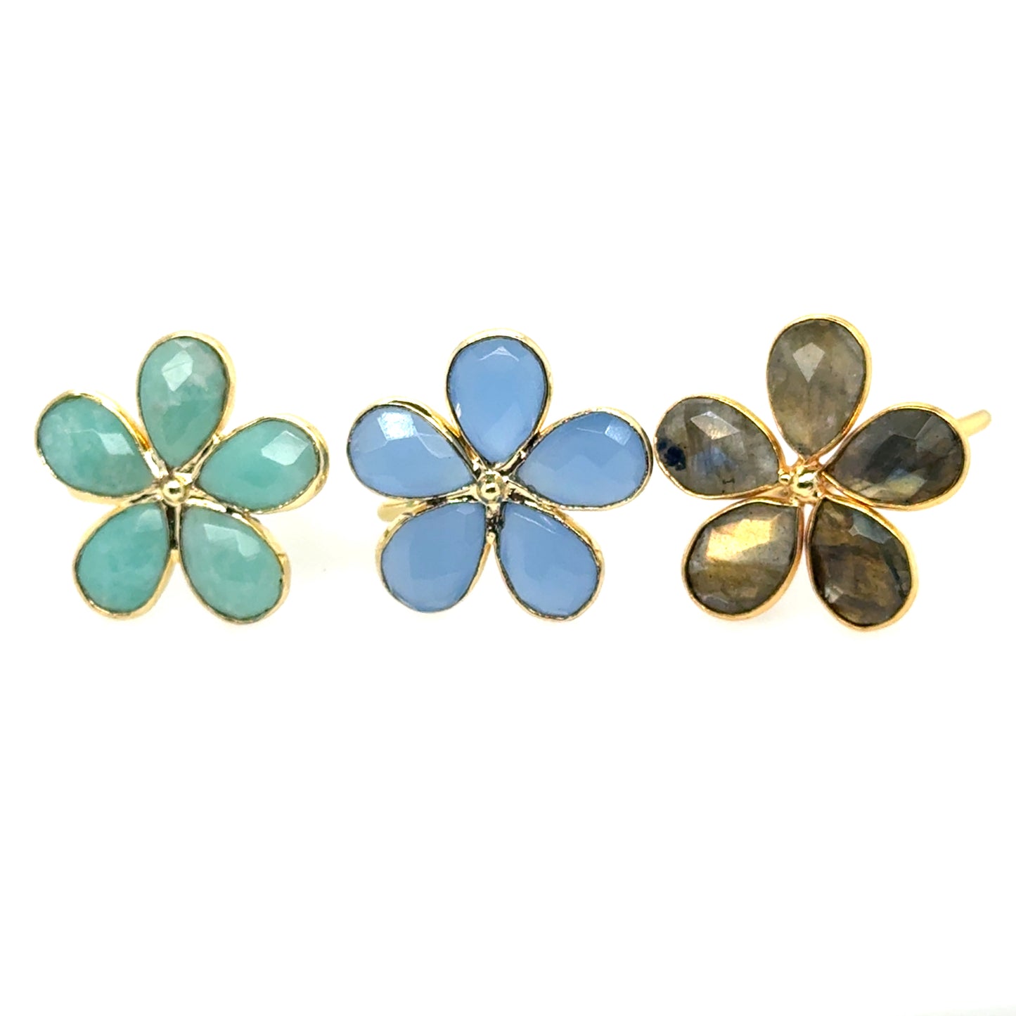Three gold rings with beautiful gemstones in the shape of a flower.