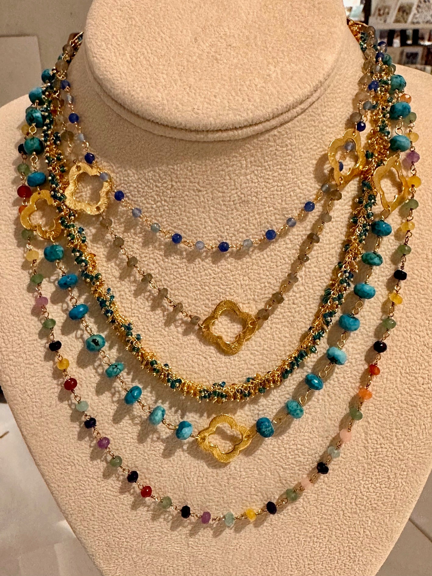 different gemstone rosary chains with flat gold clover charms.