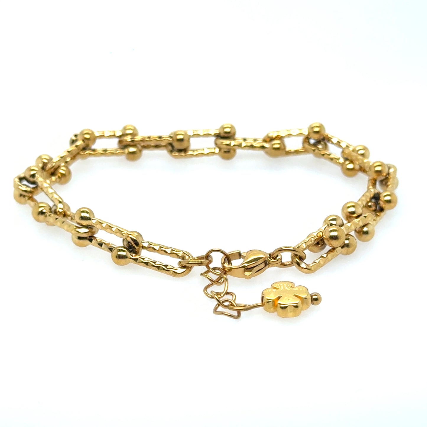 This gold bracelet has a U shaped links and hammered design with small gold clover for good luck