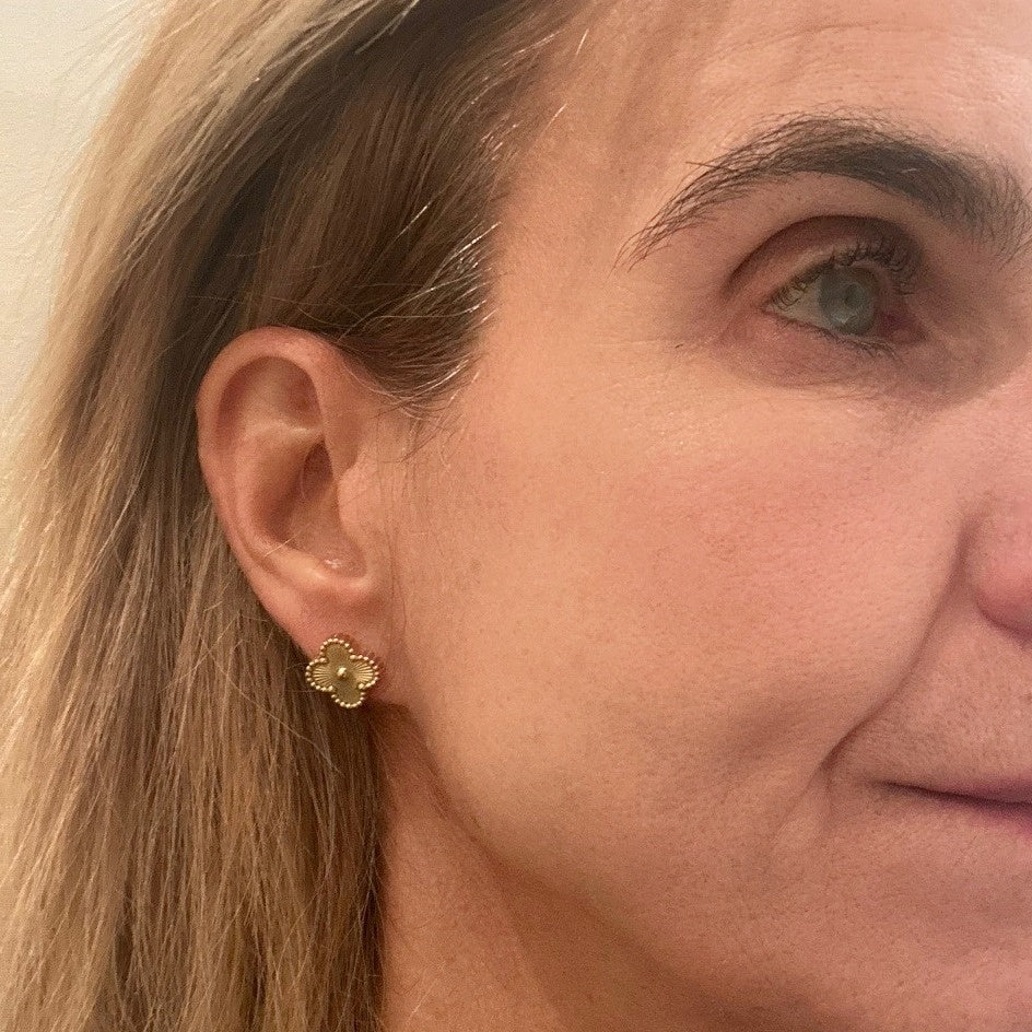 Stud earrings are made of 18K gold plated stainless steel in a clover shape om model