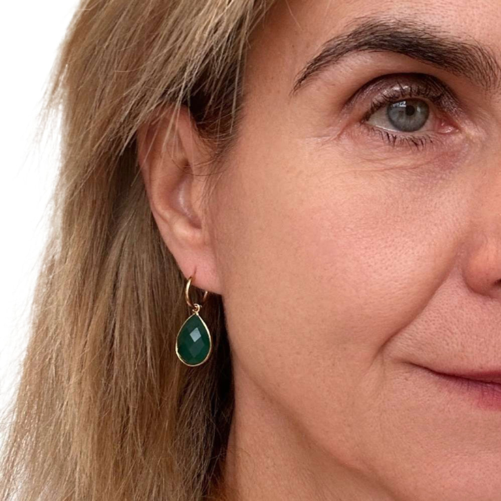 woman wearring gold hoop earrings with green agate teardrop gemstone