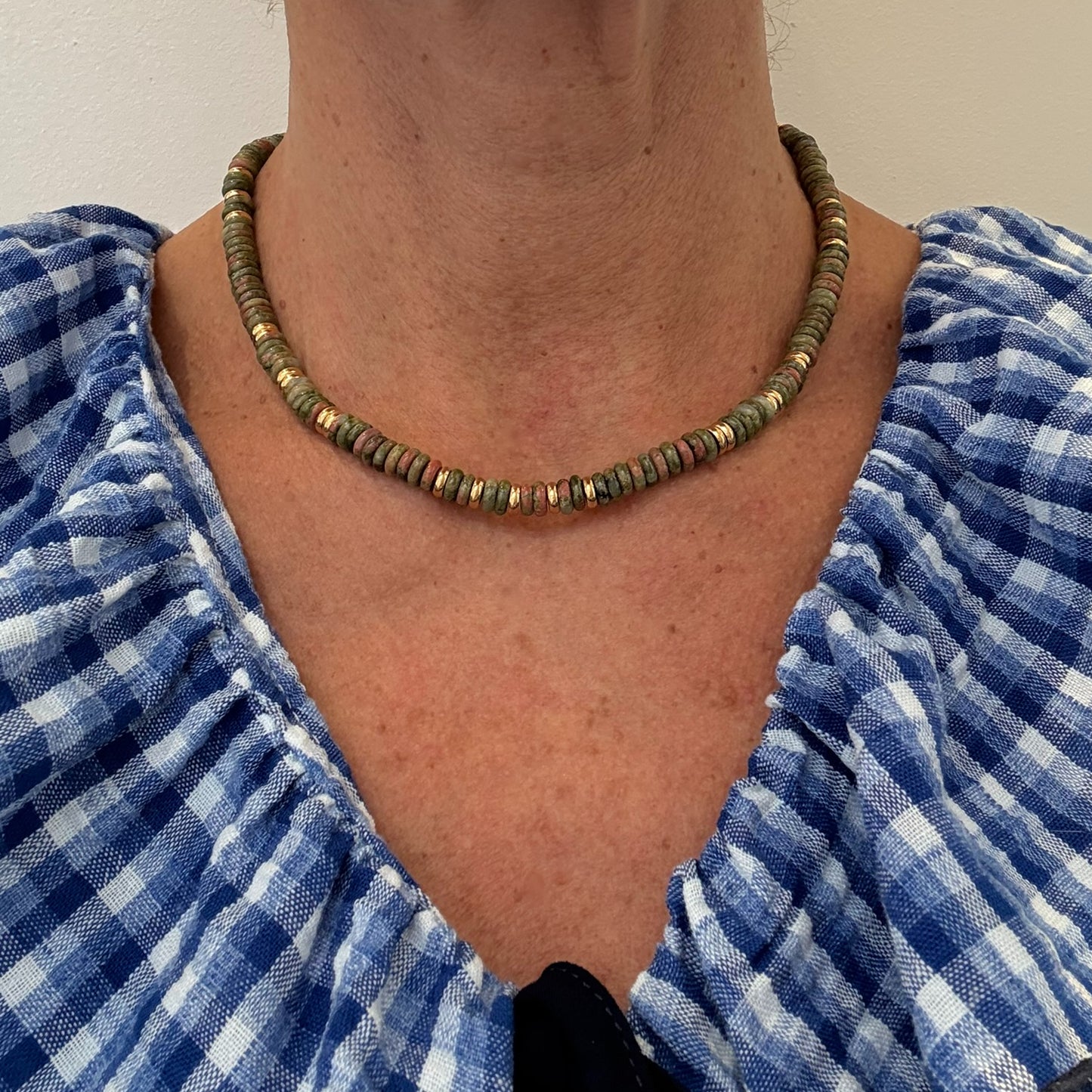 Lovely necklace with green Unakite gemstone and gold rounded beads worn on model