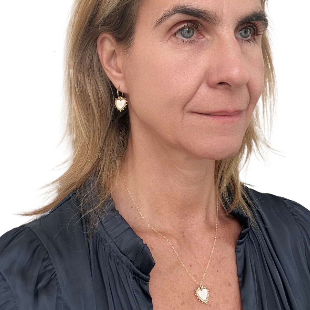 gold hoop earrings and necklace worn on model with gold and mother of pearl  heart charms