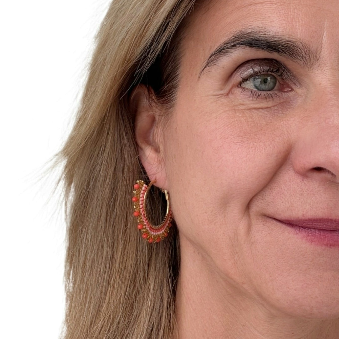 These lovely big beaded hoop earrings are orange and gold worn on model