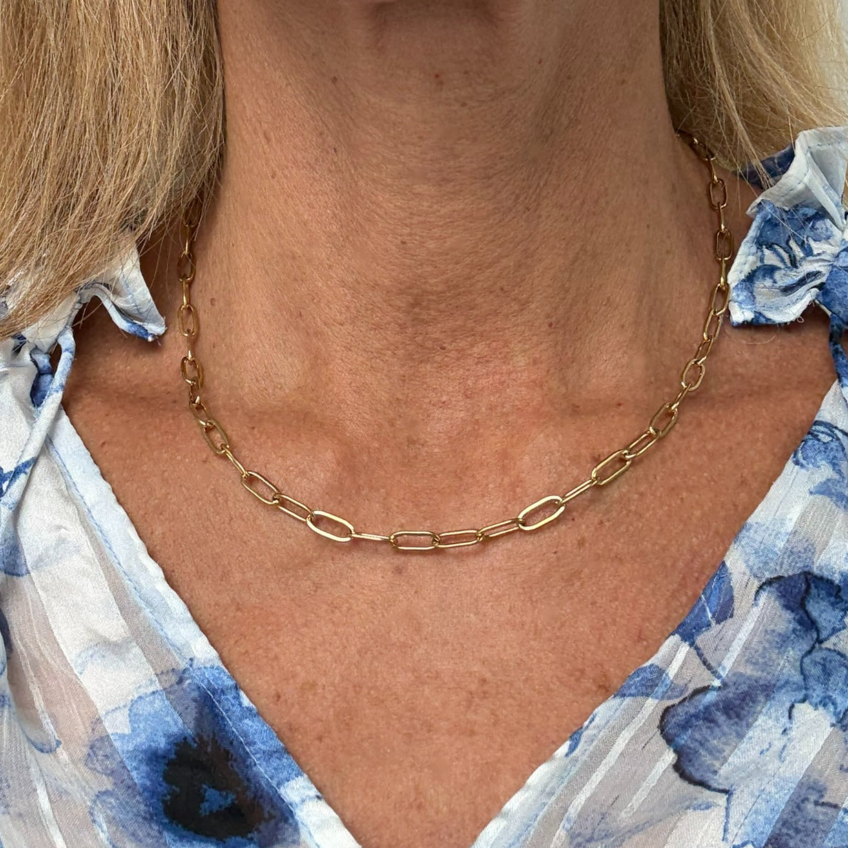 Woman wearing gold paperclip chain necklace