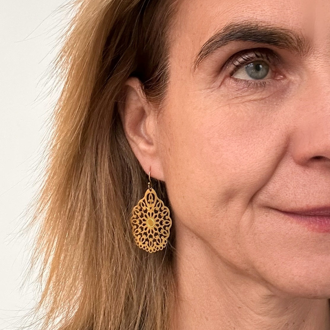 Medium bohemian patterned gold teardrop earrings on model