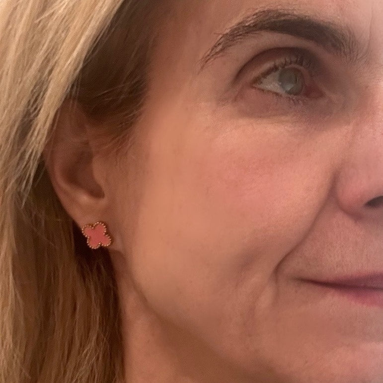 stud earrings with pink enamel in a clover shape worn on model