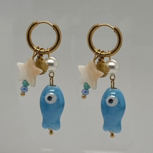 Delicate gold hoop earrings with blue porcelain fish, mother of pearl white star and tiny gold shell charms