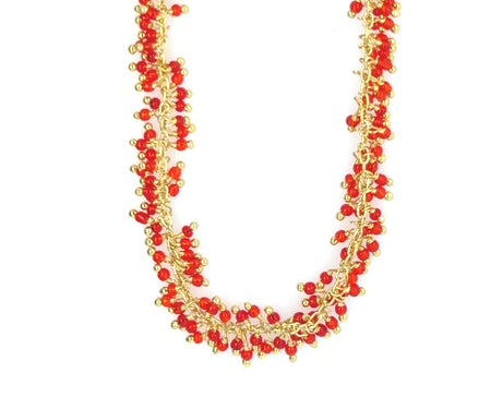 Gold necklace with red agate grape styled small charms all around close up
