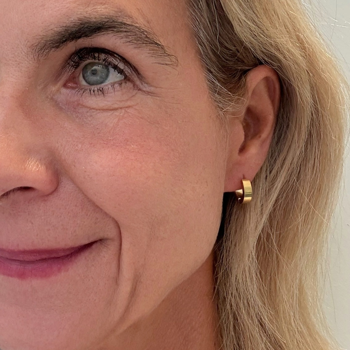 Close-up of a woman wearing a gold hoop earring.