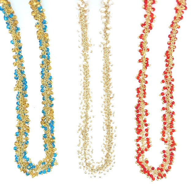 Three beaded necklaces in gold, blue, and red on a white background
