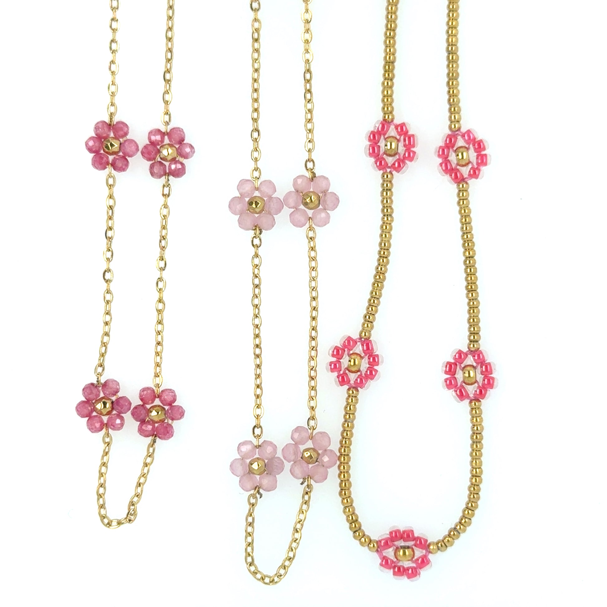 Three necklace with small light pink and gold flowers on a delicate chain