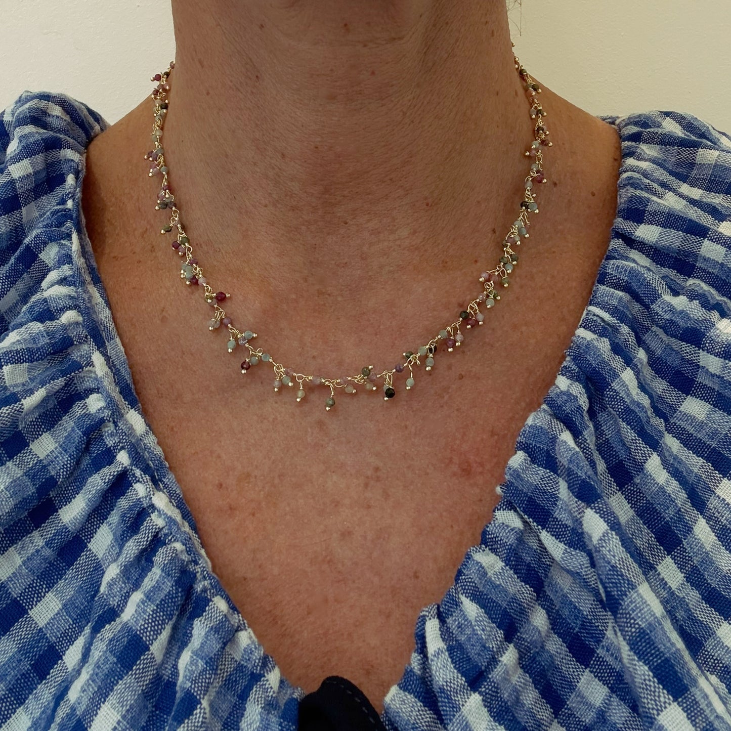 Gold necklace with lovely Tourmaline gemstone beads arranged in clusters worn on model