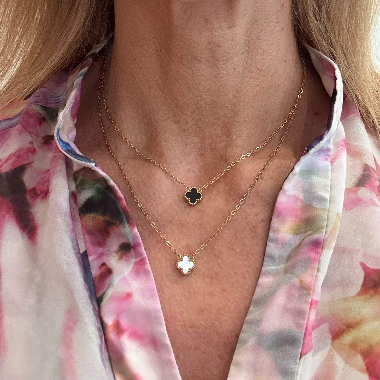 Two gold chain necklace with tiny 9mm  charms in white and black worn on  model