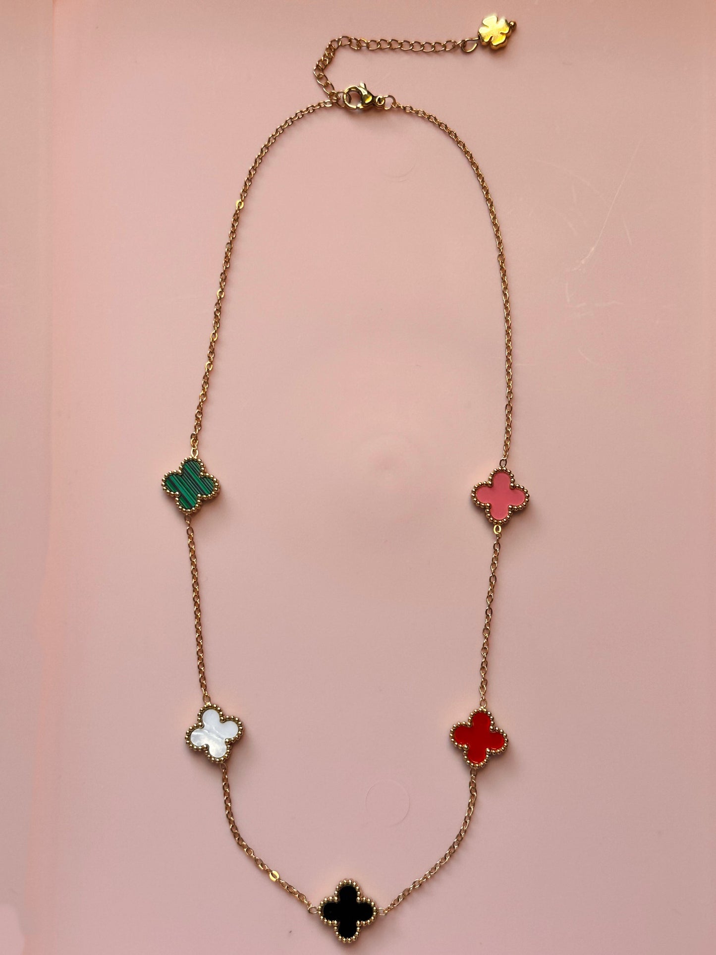 Gold chain necklace with five small clover charms in a rainbow of colours