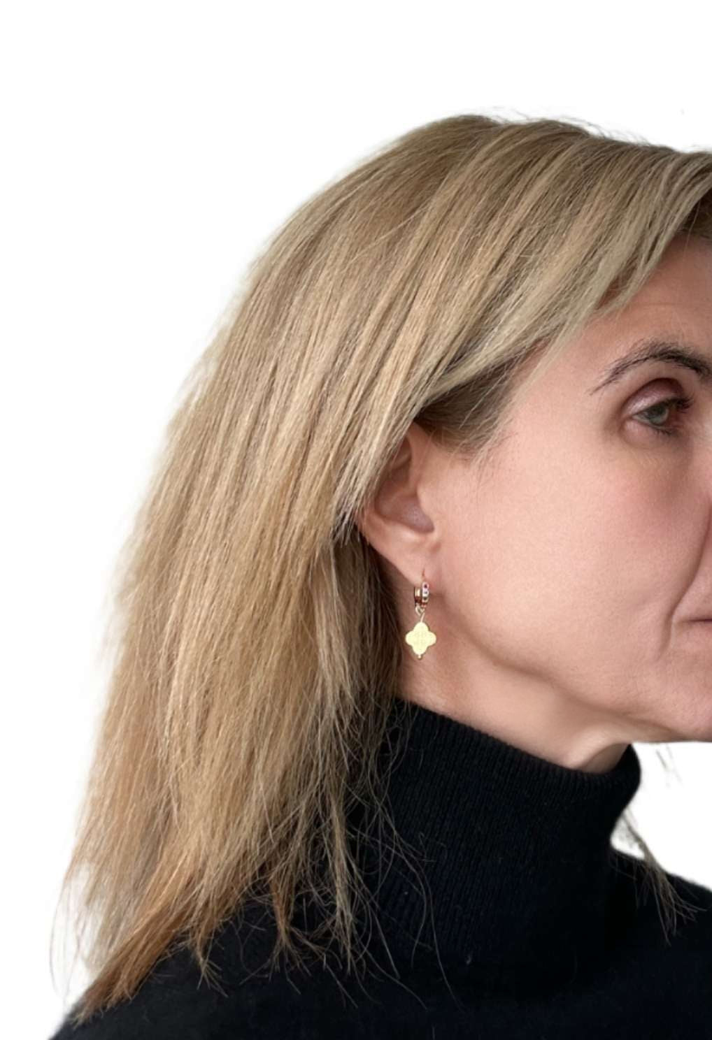 Huggie gold hoop earrings with rainbow zirconia stones and clover shaped gold charm