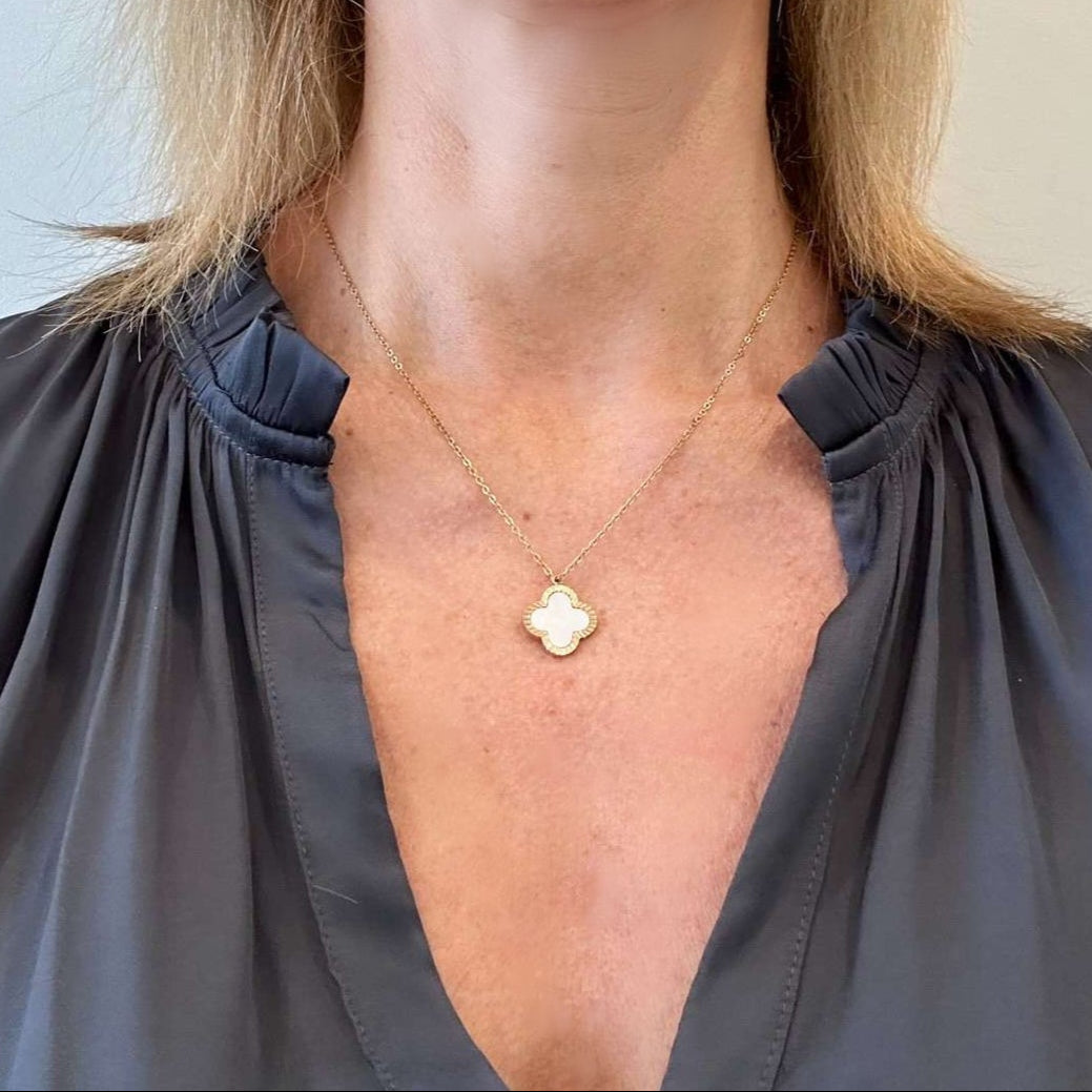 wearing necklace with mother of pearl and gold clover charm pendant
