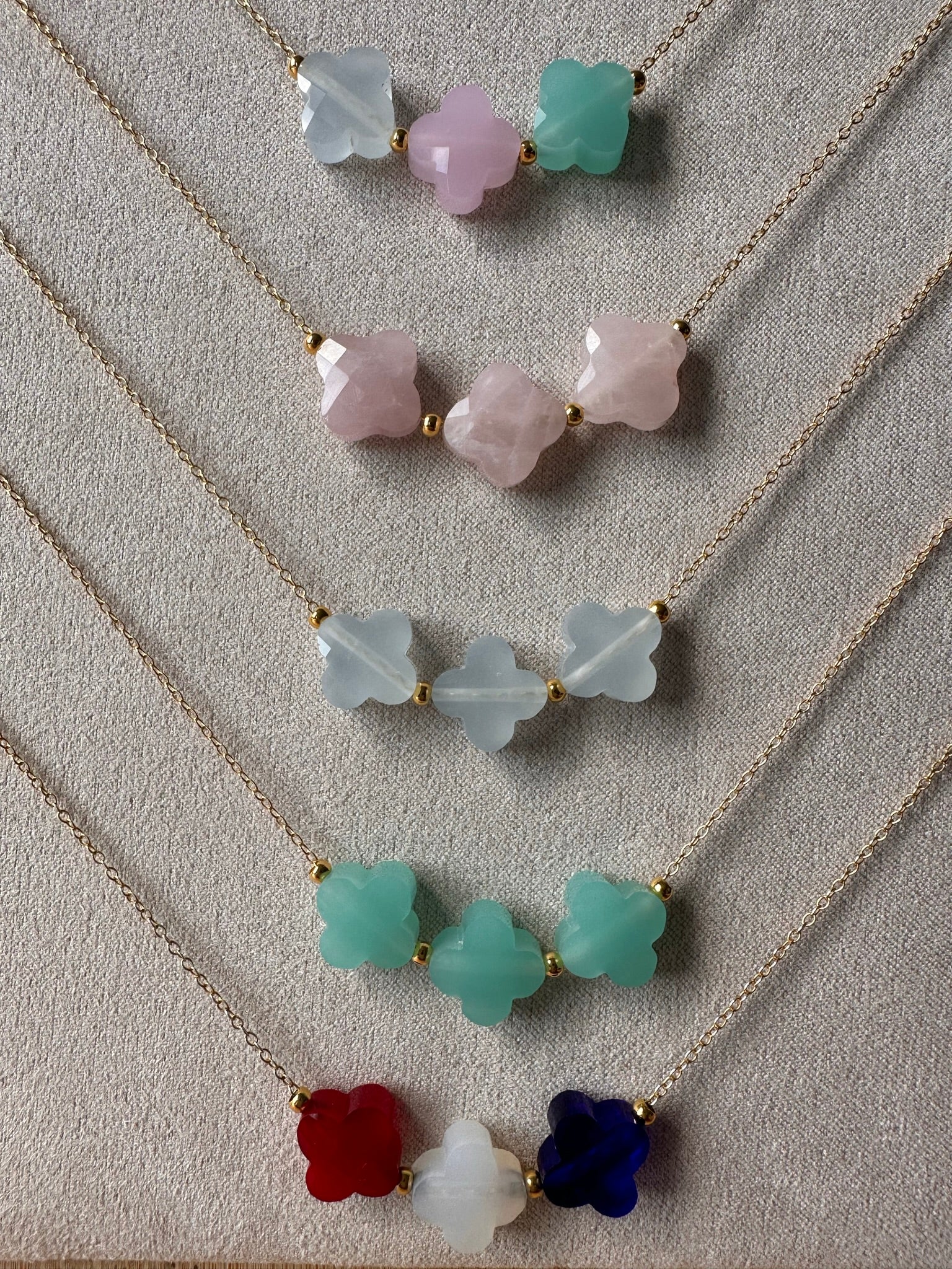 delicate gold chain necklaces with three clover charms in rainbow of colours