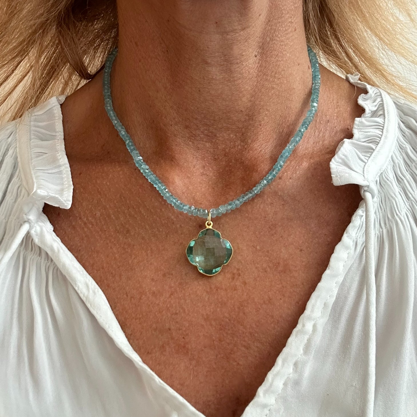 Necklace with blue Apatite gemstones all around and with one 18mm Apatite clover charm worn on model