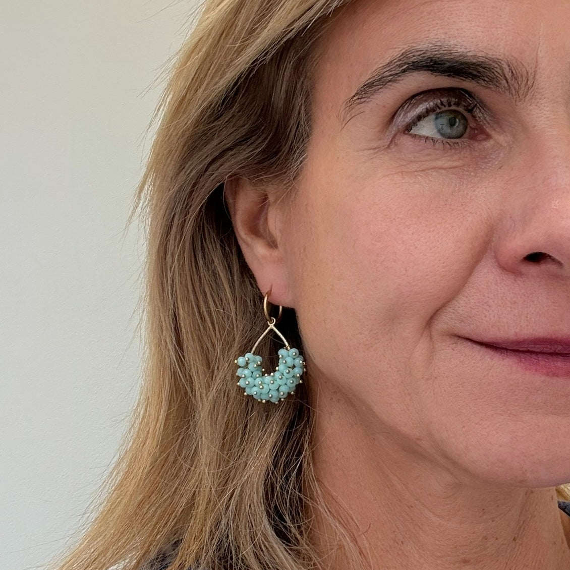 Dangling hoop earrings with small Aqua Hydro Quartz gemstone beads in teardrop shape worn on model