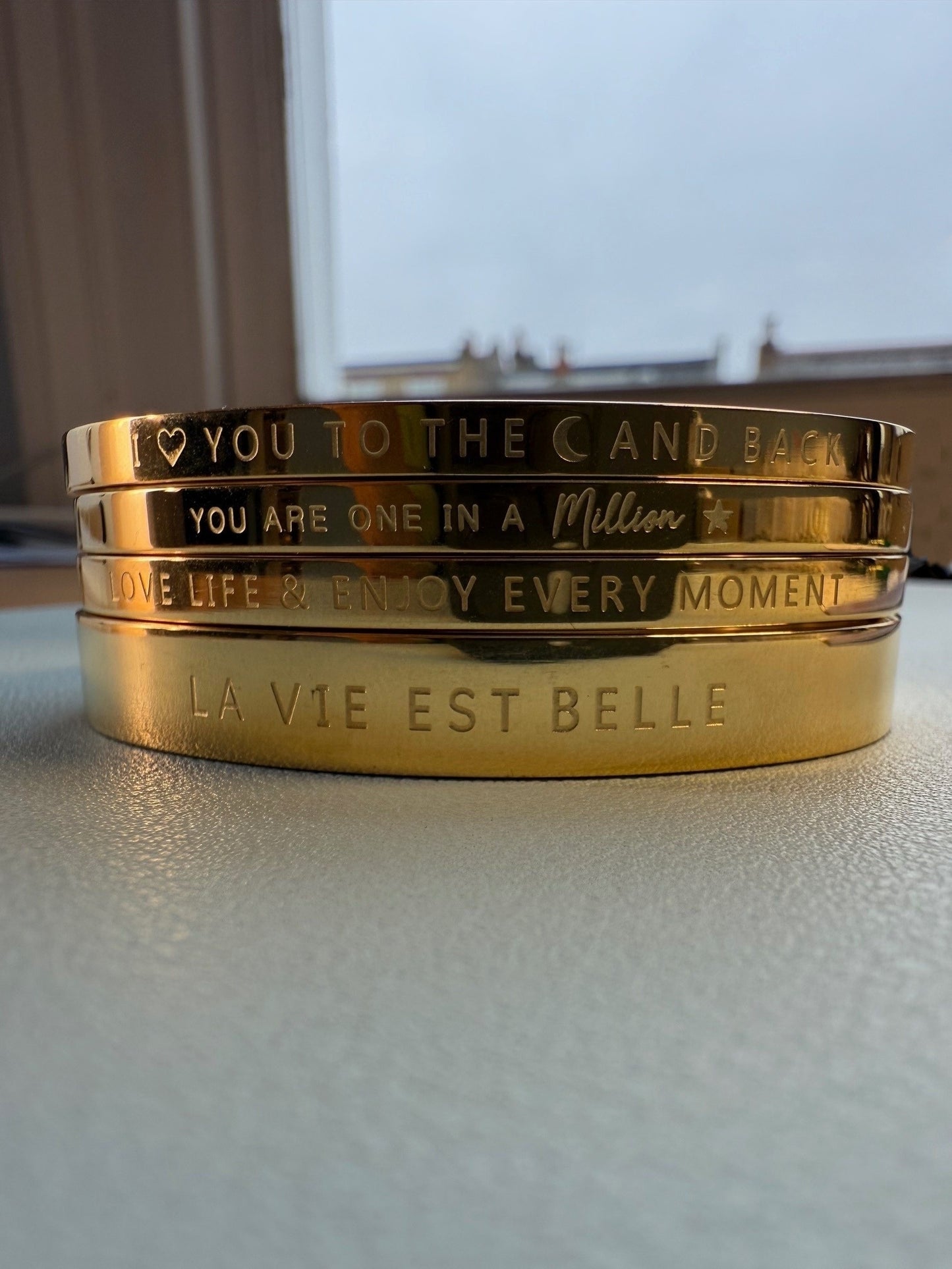 Gold bangles for the wrist which 
 have fun phrases engraved on them and clip closed