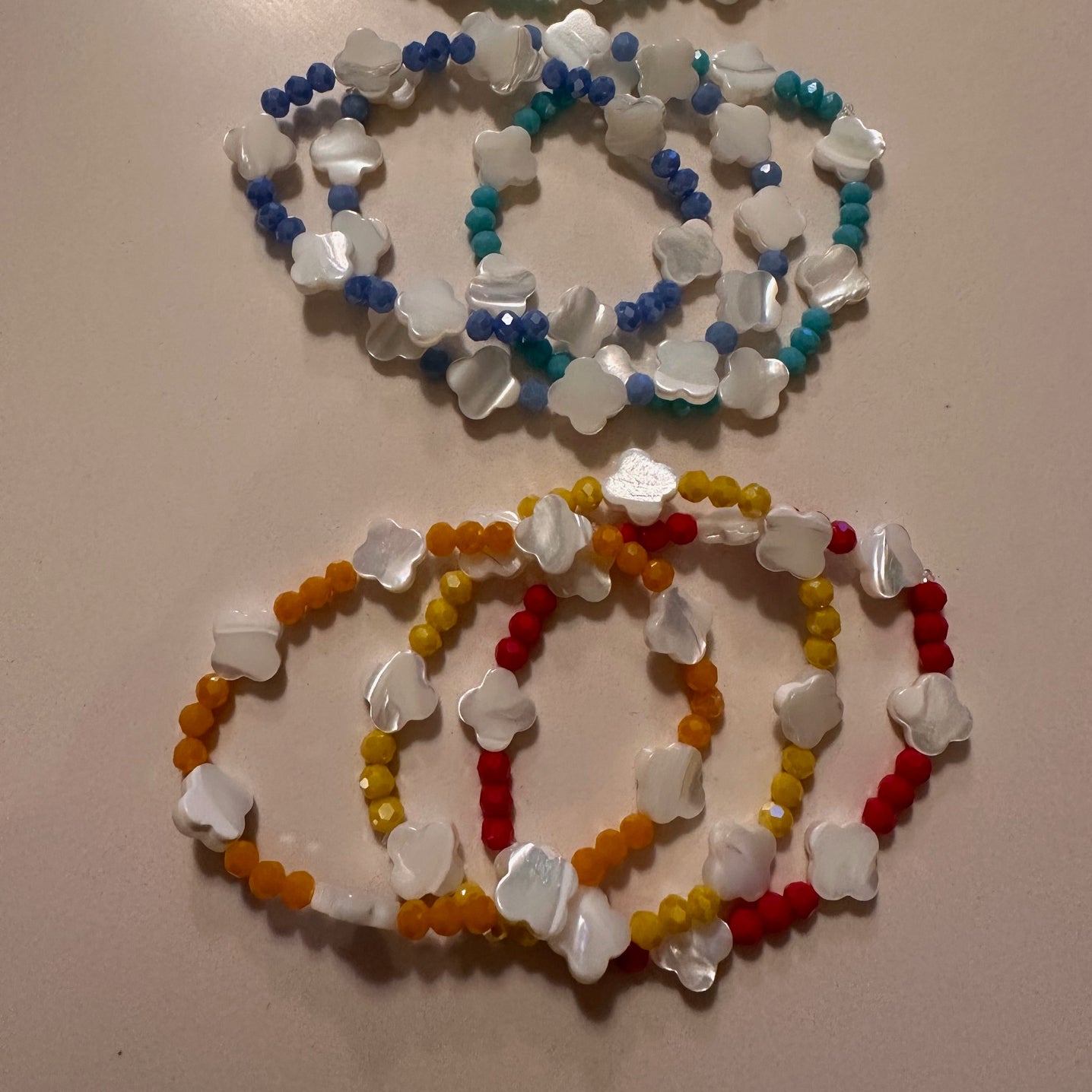 Collection of beaded bracelets on a beige surface