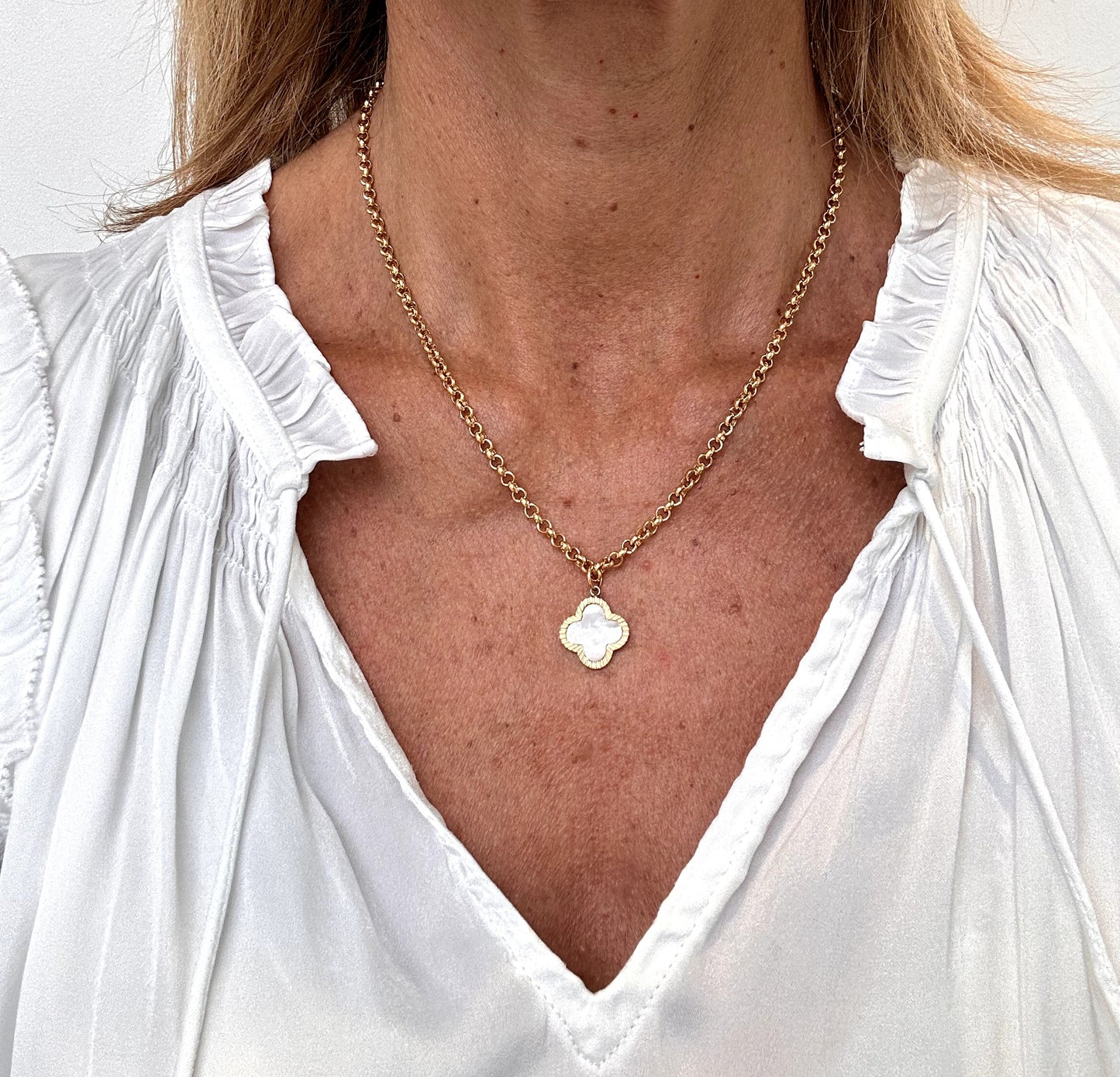 wearing large mother of pearl clover charm necklace with oval belcher chain