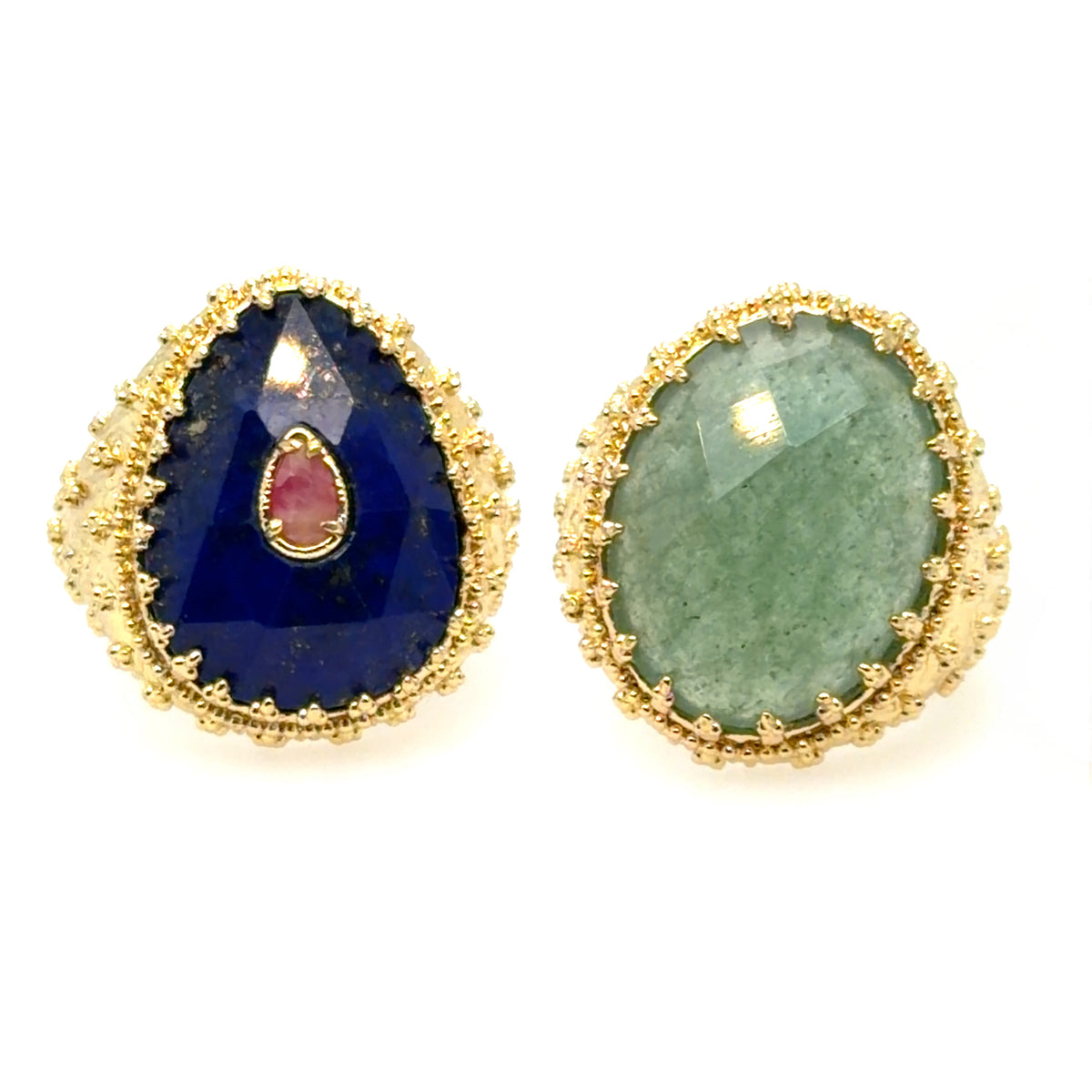 A pair of gold teardrop-shaped rings with faceted gemstones, one featuring a deep blue stone with a small pink teardrop accent, and the other featuring a light green stone.