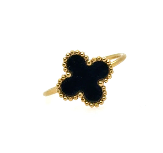 Gold ring with a black clover-shaped stone on a white background