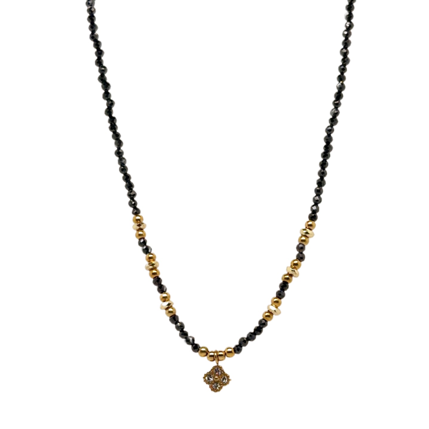 Delicate necklace with tiny black and gold beads, and dangling small sparkly clover charm
