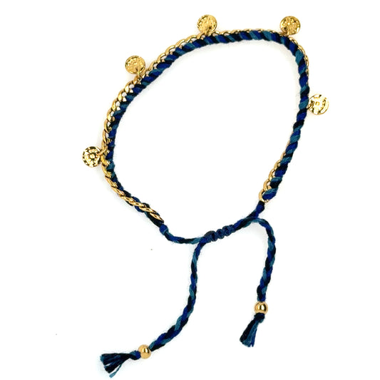 This bracelet has a gold chain interwoven with blue string and gold discs dangling all around. 