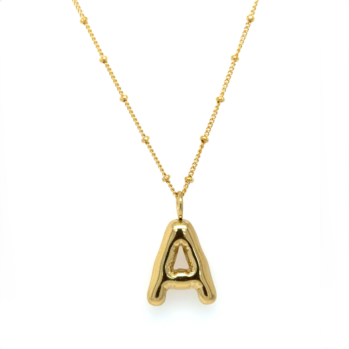 A gold initial necklace featuring a polished, open-design letter 'A' pendant suspended from a delicate gold chain with small bead accents, set against a plain white background.