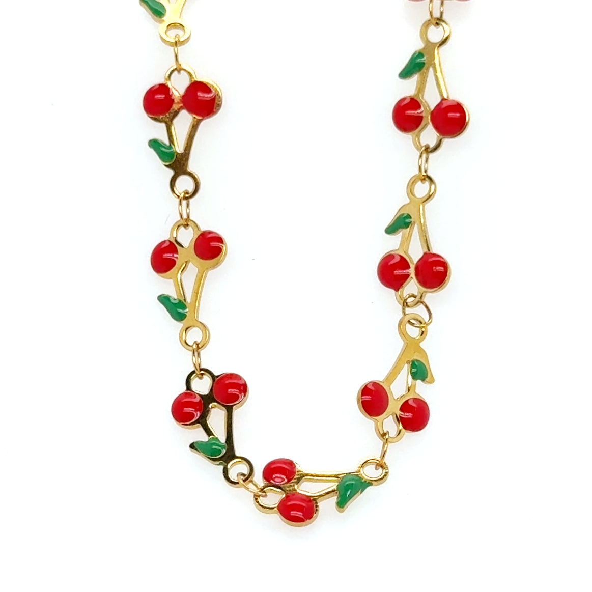Gold bracelet with red cherry pattern on a white background
