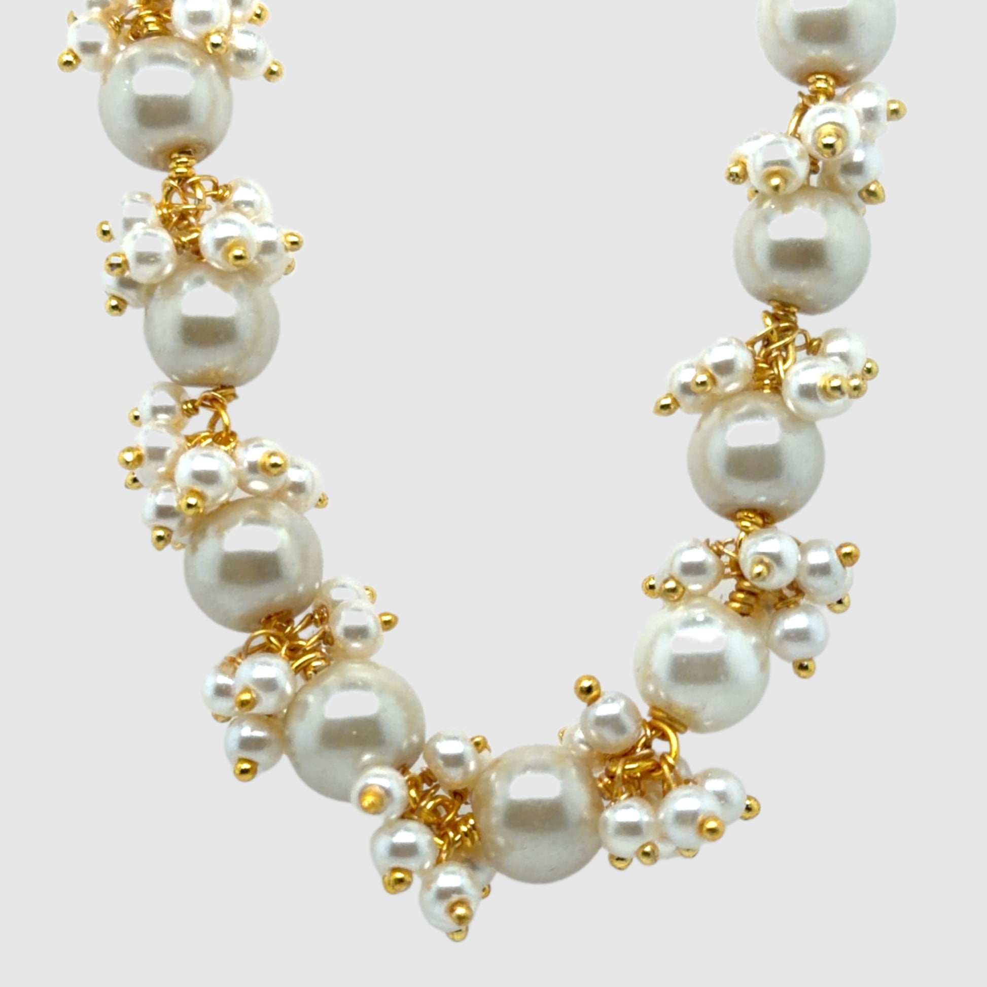 Gold necklace with Freshwater pearls arranged in big dangling clusters.