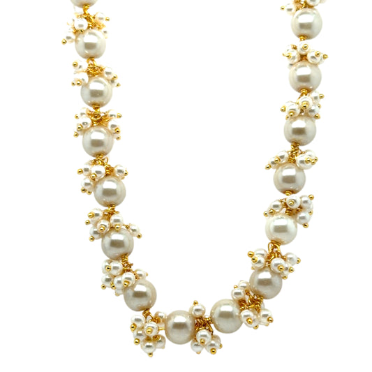 Pearl necklace with gold accents on a white background