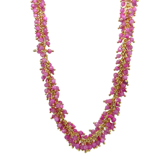 Necklace with pink beads and gold accents on a white background