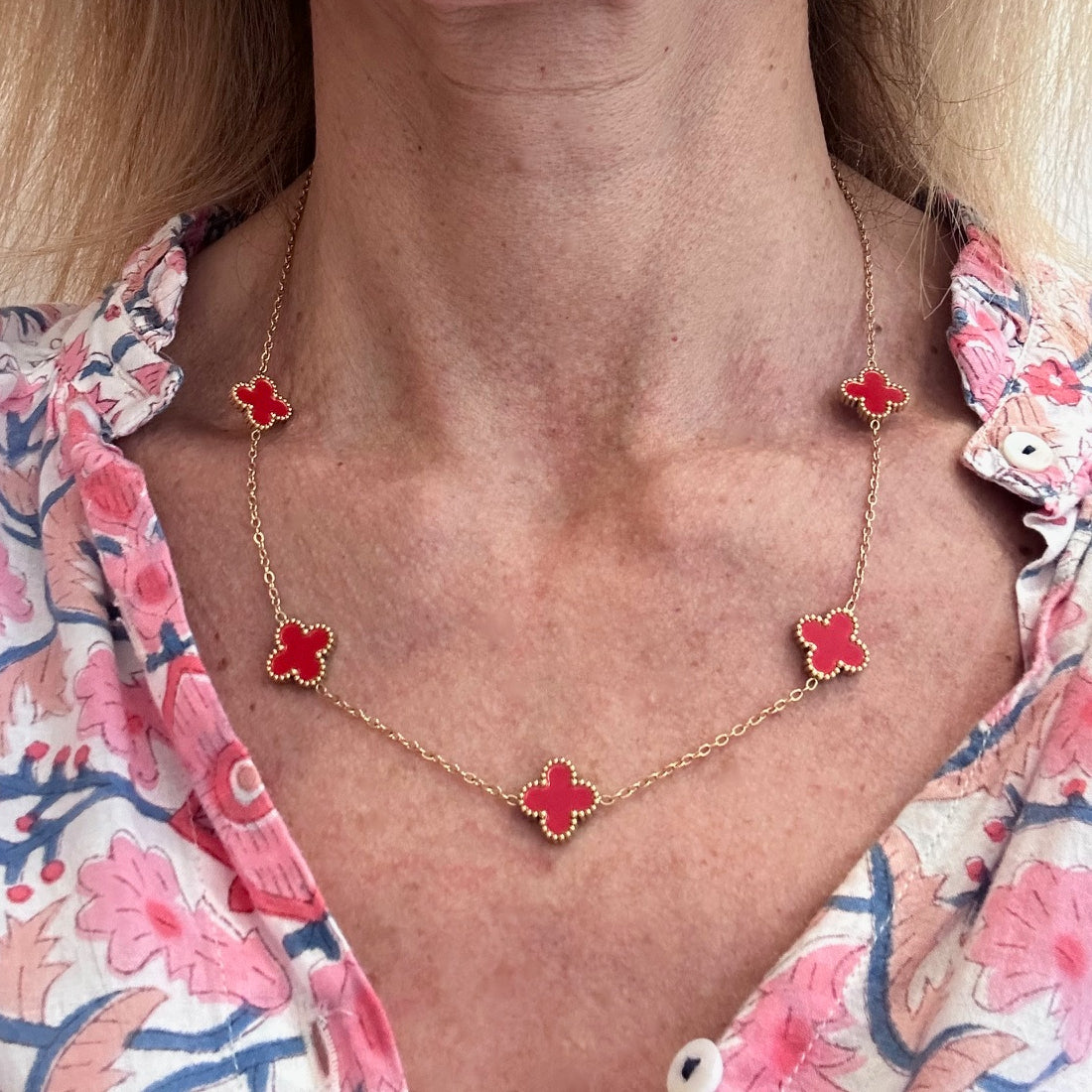 Gold chain necklace with five small red clover charms