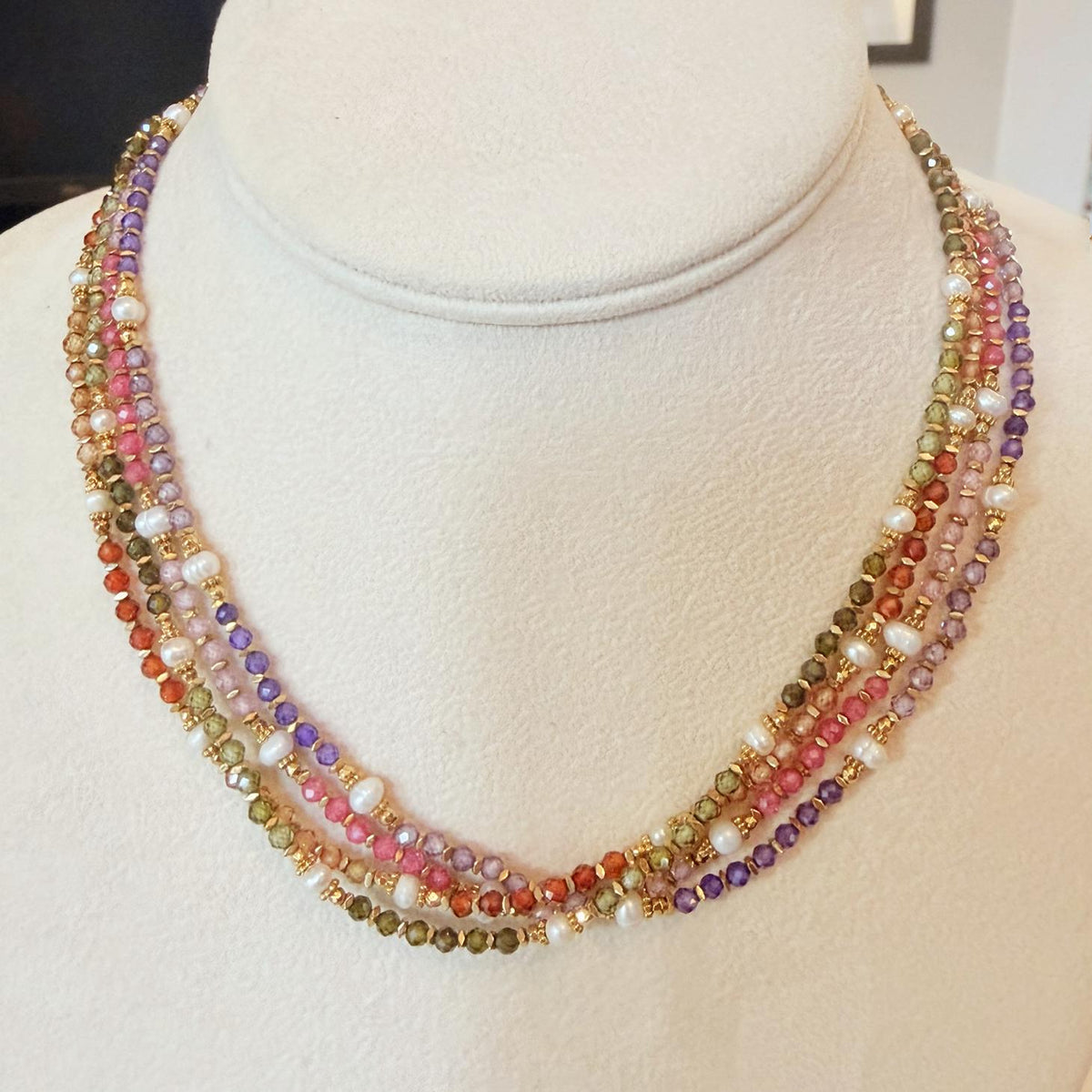 Four necklaces together with green, red, pink, purple and gold beads, and freshwater pearls