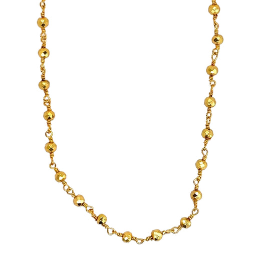 Necklace with bright golden pyrite beads all around in a rosary style.