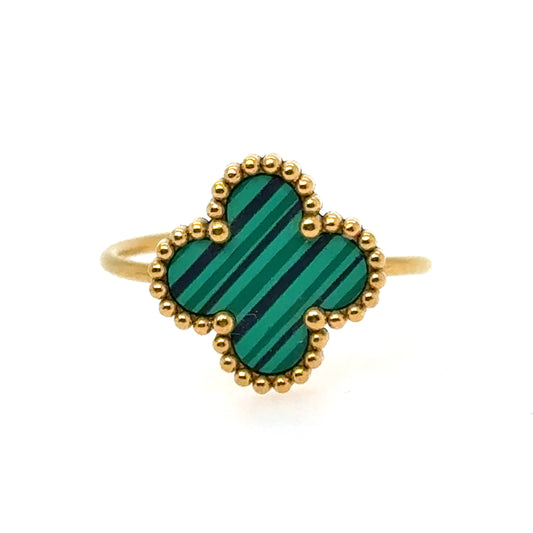 Ring with green heart-shaped stone and gold border on a white background