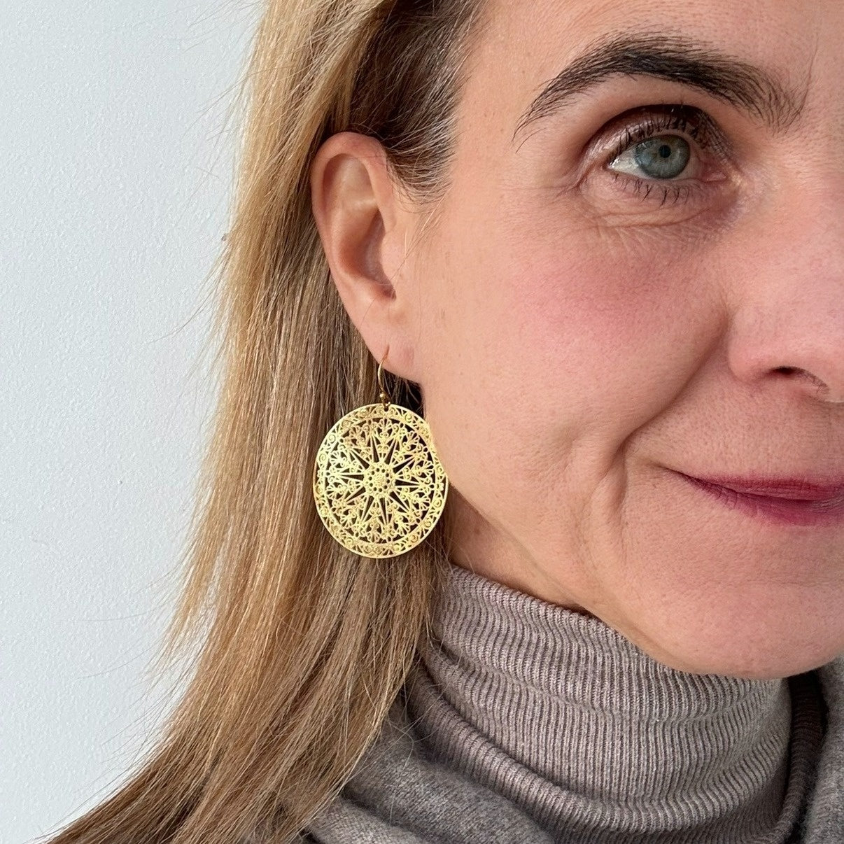 large bohemian patterned gold round earrings on model