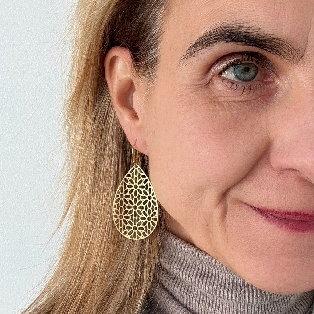 These lovely floral patterned gold teardrop earrings shown on model.