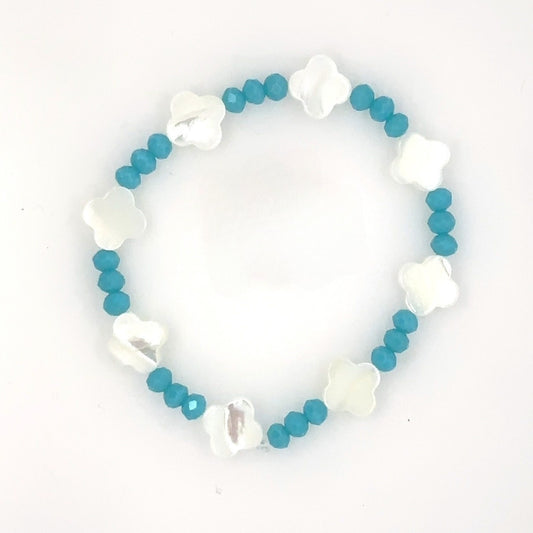 Bracelet with blue beads and white flower-shaped charms on a white background