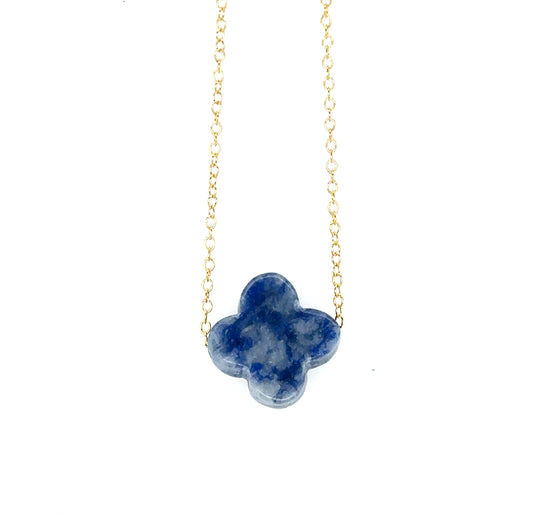 Delicate gold chain necklace with one flat stone clover charm in blue and white